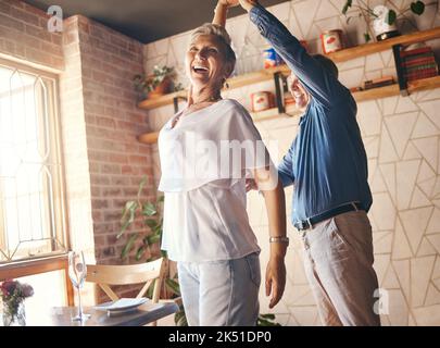 Love, happy family and dance with elderly couple celebrating and dancing to music in their home together. Wellness, stress relief and freedom by Stock Photo
