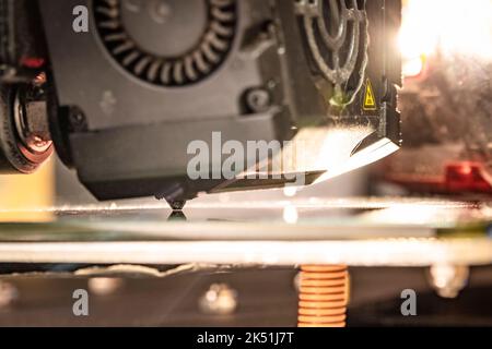 Close-up of a worn Ender 3 Max stock print head with strong warm backlight in z-offset leveling setting. Stock Photo