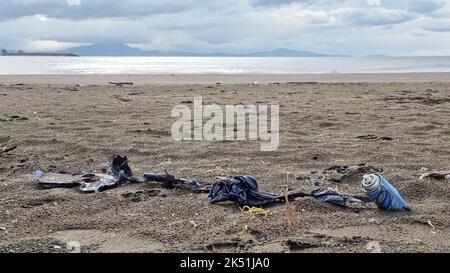 Micro plastics debris and used spray cans pollution on sea coast ecosystem,environmental waste damage Stock Photo