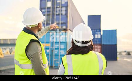 Industrial managers working on a warehouse dock to export stock, containers and packages. Teamwork, collaboration and logistics industry employees Stock Photo