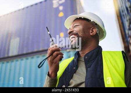 Logistics, supply chain and radio with a man delivery worker talking on a walkie talkie while working in a container yard. Ecommerce, stock and cargo Stock Photo