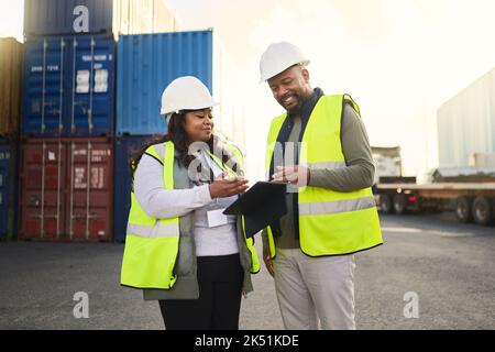 Logistics, tablet and black woman and man in container shipping yard checking online inventory list. Industrial cargo area, African workers in safety Stock Photo