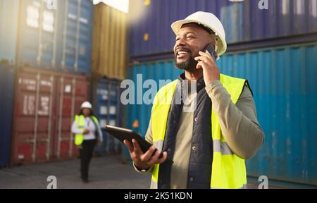 Logistics, shipping and construction worker on the phone with tablet in shipyard. Transportation engineer on smartphone in delivery, freight and Stock Photo