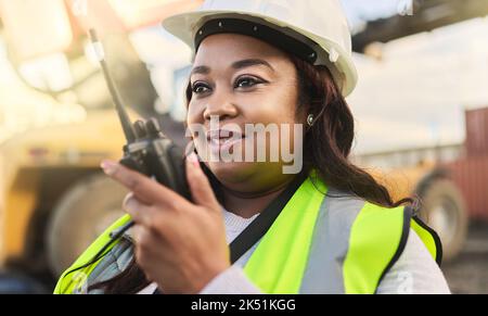 Engineer, black woman and walkie talkie for control management and communication with hardhat on inspector, manager or foreman on construction site Stock Photo