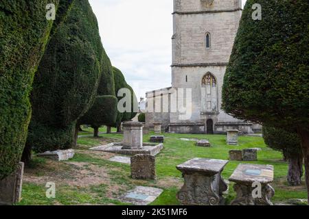 The churchyard at St. Mary's Church in Painswick, Gloucestershire is famous for its yew trees Stock Photo