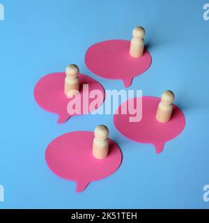 Wooden dolls on speech bubble. Reviews, opinion and comments. Communication, mutual relations and brainstorming concept Stock Photo
