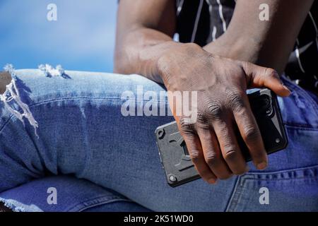 African person working remotely on mobile. Online communication Stock Photo