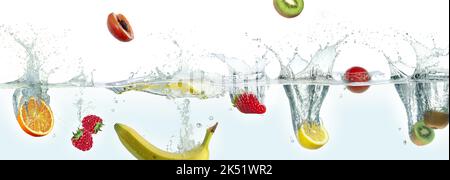 Various fruits splashing in water. Side panoramic view on white background. Stock Photo