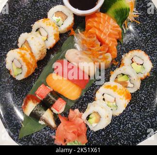 Top view of assorted sushi and soy sauce on dark platter Stock Photo