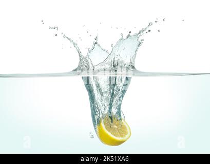 Half lemon splashing in clear water. Side view on white background. Stock Photo