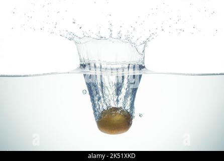 Kiwi splashing in water. Side view on white background. Stock Photo