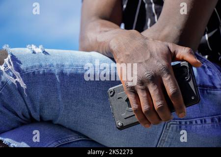 African person working remotely on mobile. Online communication Stock Photo