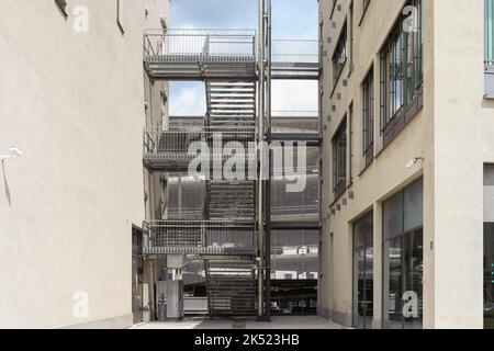 Outdoor stairs between two houses at a parking garage with stores - landscape format Stock Photo