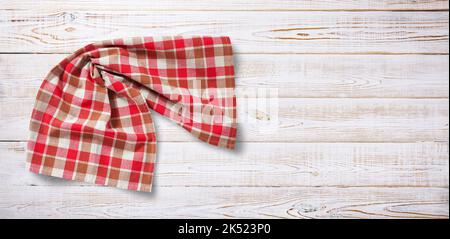 Towel or tablecloth, napkin, rough fabric texture with creased folds on wooden desk. Top view. Stock Photo