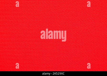 Close-up long and wide texture of natural red fabric or cloth in light red color. Fabric texture of natural cotton or linen textile material. Red canv Stock Photo