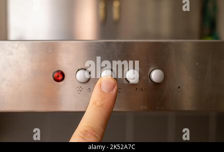 man finger pressing button on dirty metal panel Stock Photo