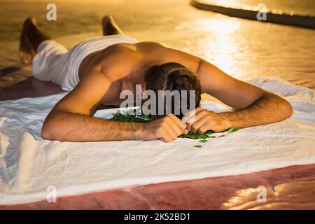 Actor fakir stuntman lies face on broken glass Stock Photo