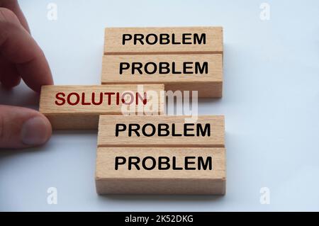 Hand putting wooden block with word solution in the middle of wooden blocks with words problem. Solution concept. Stock Photo
