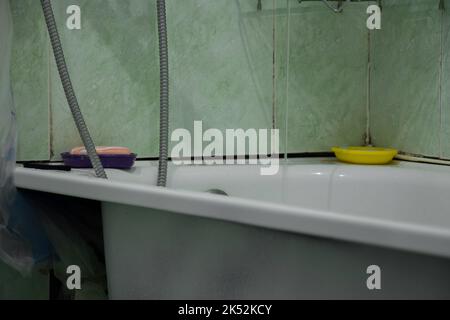 an old bathroom in a Soviet apartment without renovation, a bathroom with old renovations, a bathroom Stock Photo