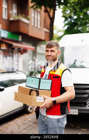 Portrait of the worker , courier at work in front of his van on the street Stock Photo