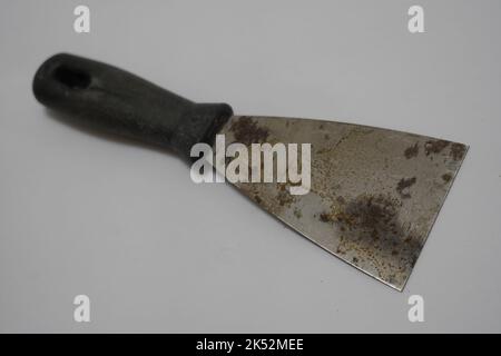 Putty knives with wooden handles,  Closeup a new metallic putty knife isolated on white background. Single knife with black red rubber grip Stock Photo