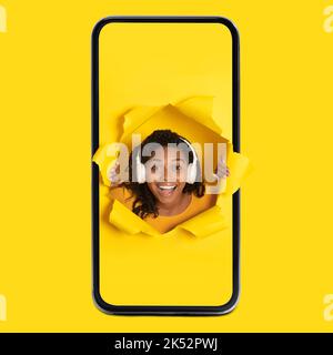 Black Woman In Cellphone Listening Music Wearing Headphones, Yellow Background Stock Photo