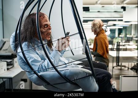 Zombie employee chatting social network in office lounge area Stock Photo