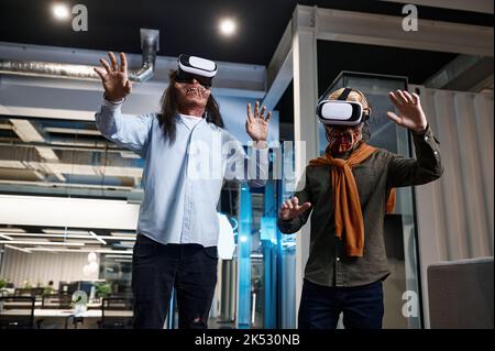 Creepy zombie employees using virtual reality technology Stock Photo