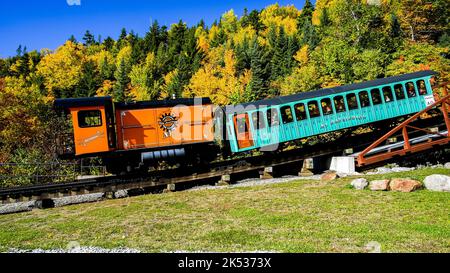 BASE STATION ROAD, NEW HAMPSHIRE, USA - OCTOBER 2, 2022: Modern biodiesel locomotive from Cog Railway is returning from Mount Washington with tourist Stock Photo