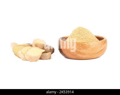 Ground ginger in a bowl and fresh ginger root on a white background. Copy space. Stock Photo
