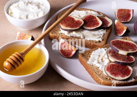 Fresh zeon bread with ricotta, figs, dry herbs and honey. Stock Photo