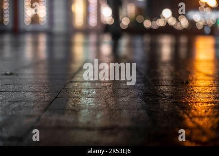 Night urban landscape, colored lights reflected in the wet asphalt in fall. The lights of a rainy night in the autumn city of disfocus and bokeh. Neon Stock Photo