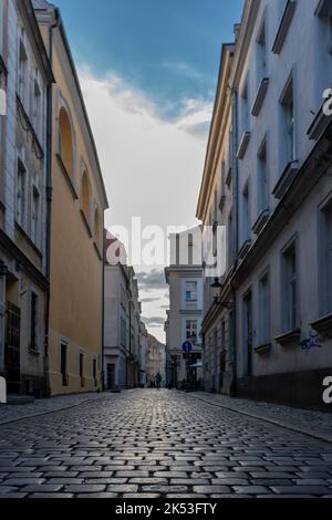 A vertical shot of a narrow street between buildings with painted ...