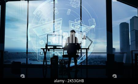 A woman web developer working at a computer in her office against the background of a panoramic window and infographic. Stock Photo