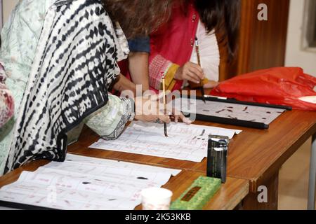 Islamabad, Pakistan. 5th Oct, 2022. Students learn Chinese calligraphy during a Chinese language class in Islamabad, capital of Pakistan, on Oct. 5, 2022. Credit: Ahmad Kamal/Xinhua/Alamy Live News Stock Photo