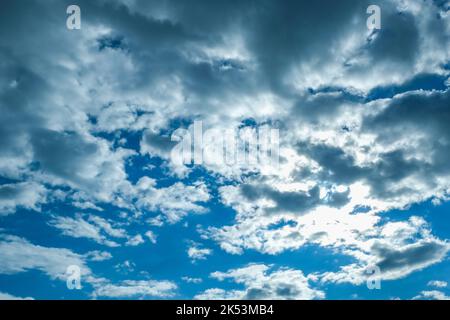 Blue sky with thunderclouds. The sun breaks through the clouds. Black clouds. Stock Photo