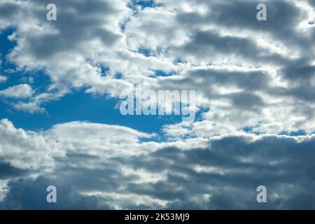 Blue sky with thunderclouds. The sun breaks through the clouds. Black clouds. Stock Photo