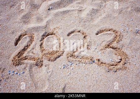 New Year 2023. Figures on the sandy shell seashore. Stock Photo