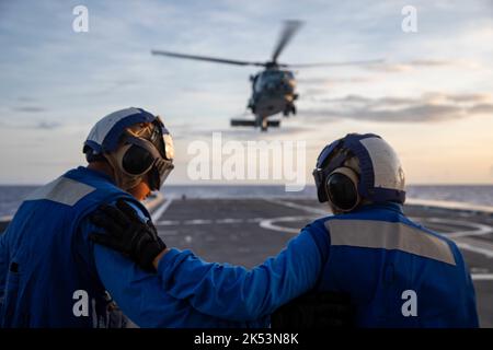 PHILIPPINE SEA (Sept. 23, 2022) – Seaman Amin Moffett, from Memphis, left, and Boatswain’s Mate Seaman Apprentice Brianda Ruiz, from Albuquerque, New Mexico, standby to secure an MH-60R Sea Hawk helicopter on recovery, assigned to Helicopter Maritime Strike Squadron (HSM) 35 aboard the guided-missile destroyer USS Zumwalt (DDG 1000) while operating in the Philippine Sea, Sept. 23. Zumwalt is conducting underway operations in support of a free and open Indo-Pacific. (U.S. Navy photo by Mass Communication Specialist 2nd Class Jaimar Carson Bondurant) Stock Photo