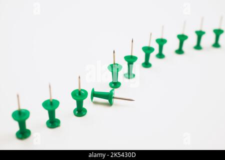 Green pushpins on white background. Stock Photo