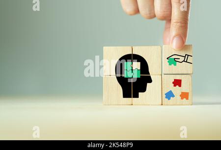 New ideas, sharing, creative thinking, mental health concept. Mental health day. Wooden cubes isolated brain with jigsaw puzzle pieces symbol on grey Stock Photo
