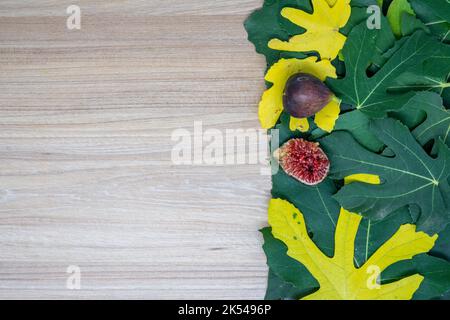 Creative layout of fig leaves and fresh fruit in autumn on the table with neutral space. Flat lay concept. Great for presentation slide background. Stock Photo