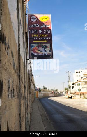 Advertisements hanged on the barrier wall built by Israel in the West Bank, Palestine. Stock Photo