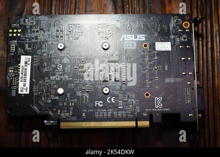 The back side of the Asus AMD Radeon RX550 graphics card lying on the table: Russia - January 2021 Stock Photo