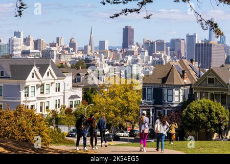 San Francisco, California, USA - September 29, 2019: People enjoying outdoor activities and view of Painted Ladies houses in Alamo Square with backgro Stock Photo