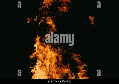 A Fire embers particles over black background. Fire sparks background. Abstract dark glitter fire particles lights. bonfire in motion blur. Stock Photo