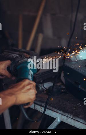 A person using a grinder in workshop Stock Photo