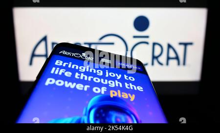 Mobile phone with website of gambling company Aristocrat Leisure Limited on screen in front of business logo. Focus on top-left of phone display. Stock Photo