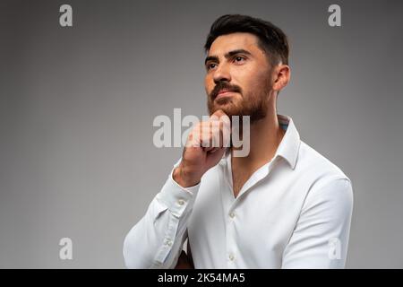 Studuo shot of thinking businessman standing over gray background Stock Photo