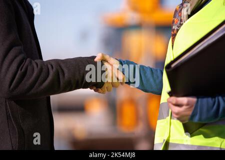 Where the architects meet the builders...a construction worker shaking hands with the architect. Stock Photo